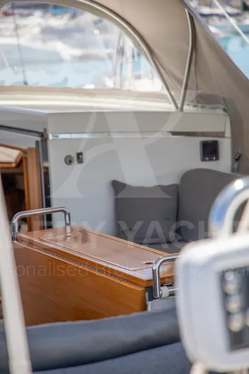 Satori Yacht Photos Pics Interior view of a 2005 Farr 64 yacht, featuring cushioned seating and wooden accents.