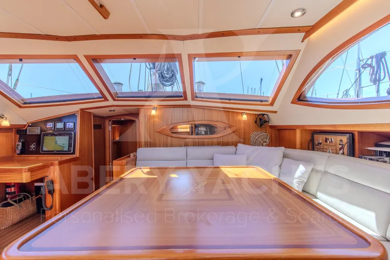 Satori Yacht Photos Pics Luxurious interior of 2005 Farr 64 yacht with elegant wood finish and large windows.