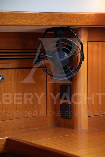 Satori Yacht Photos Pics Wooden interior of a 2005 Farr 64 yacht with a mounted fan.