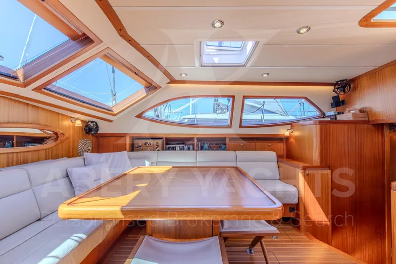 Satori Yacht Photos Pics Luxurious interior of a 2005 Farr 64 yacht with elegant wood finish and ample seating.
