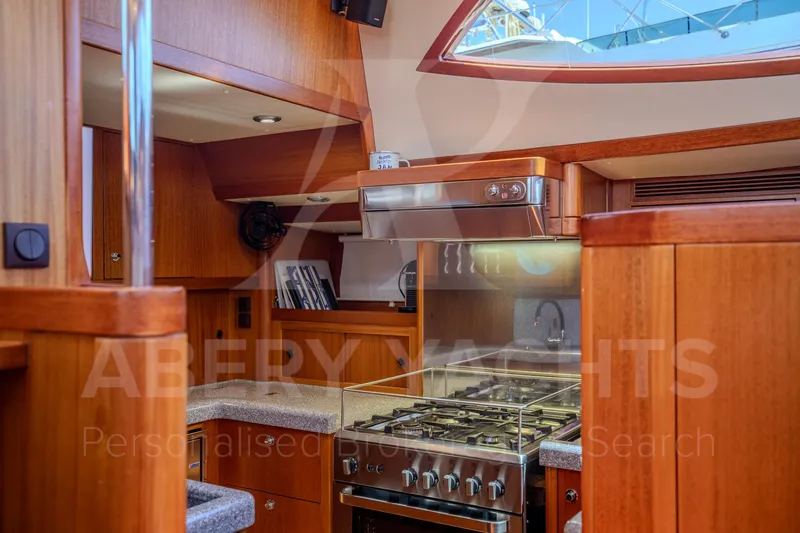 Satori Yacht Photos Pics Luxurious kitchen interior of a 2005 Farr 64 yacht with wooden cabinetry and modern appliances.