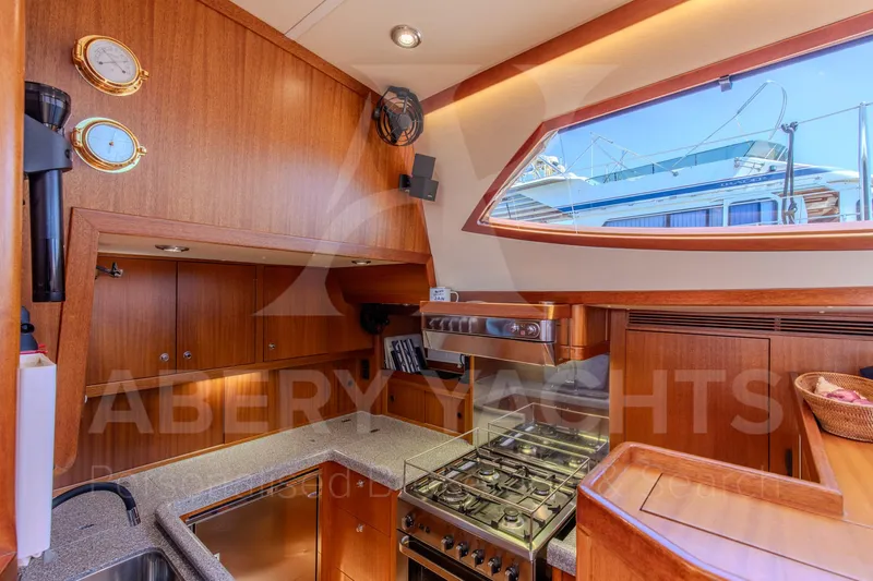 Satori Yacht Photos Pics Luxurious Farr 64 yacht kitchen interior, 2005 model, featuring wood cabinetry and modern appliances.