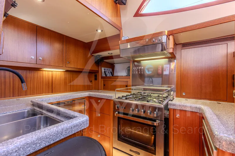 Satori Yacht Photos Pics Luxurious Farr 64 yacht kitchen, 2005 model, featuring wood cabinetry and modern appliances.