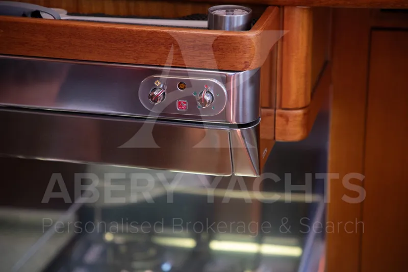 Satori Yacht Photos Pics Control panel of a 2005 Farr 64 yacht, featuring wood and stainless steel design.