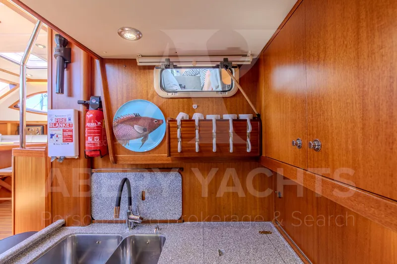 Satori Yacht Photos Pics Galley of 2005 Farr 64 yacht with wooden cabinets and stainless steel sink.