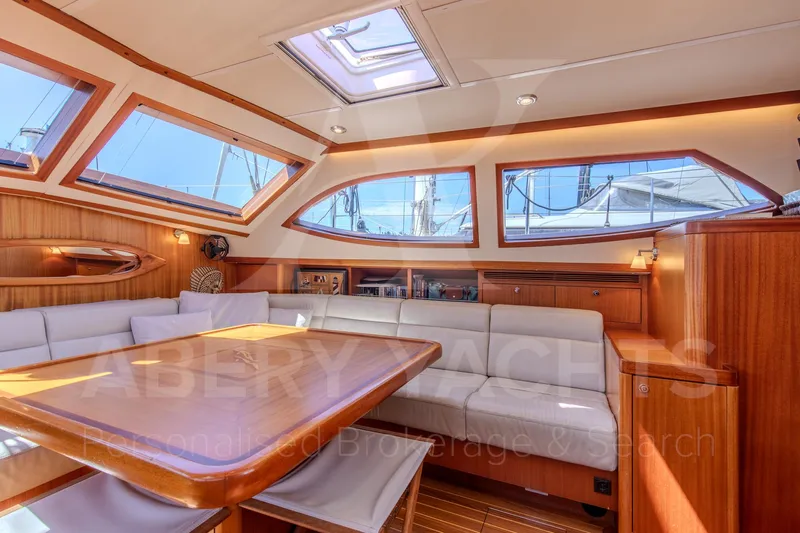 Satori Yacht Photos Pics Luxurious interior of a 2005 Farr 64 yacht with elegant wood finishes and ample seating.
