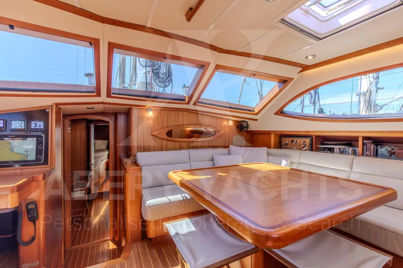 Satori Yacht Photos Pics Luxurious interior of a 2005 Farr 64 yacht with elegant wood finishes and ample seating.