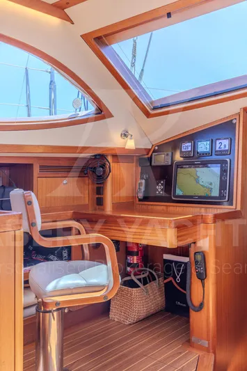 Satori Yacht Photos Pics Interior of 2005 Farr 64 yacht with navigation equipment and wooden finish.