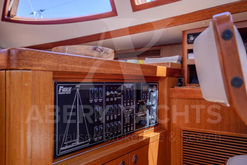 Satori Yacht Photos Pics Control panel of a 2005 Farr 64 yacht, featuring wooden interior and navigation equipment.