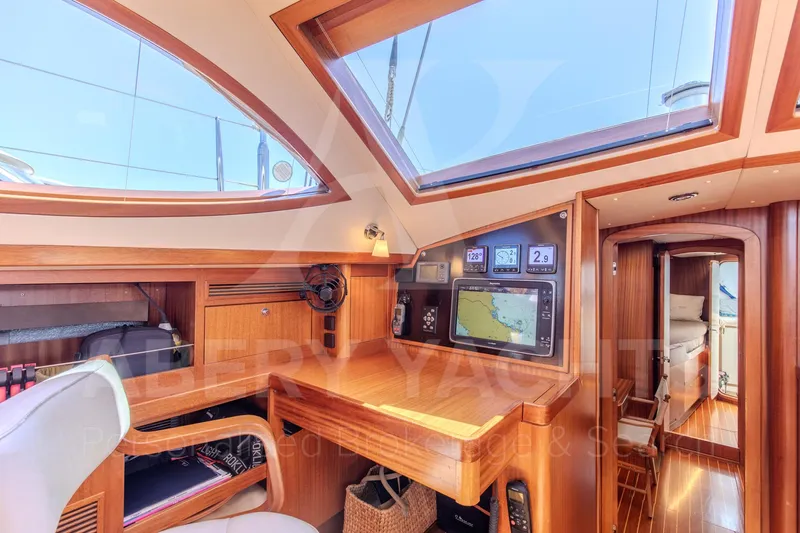 Satori Yacht Photos Pics Luxurious interior of 2005 Farr 64 yacht with navigation equipment and wooden finish.