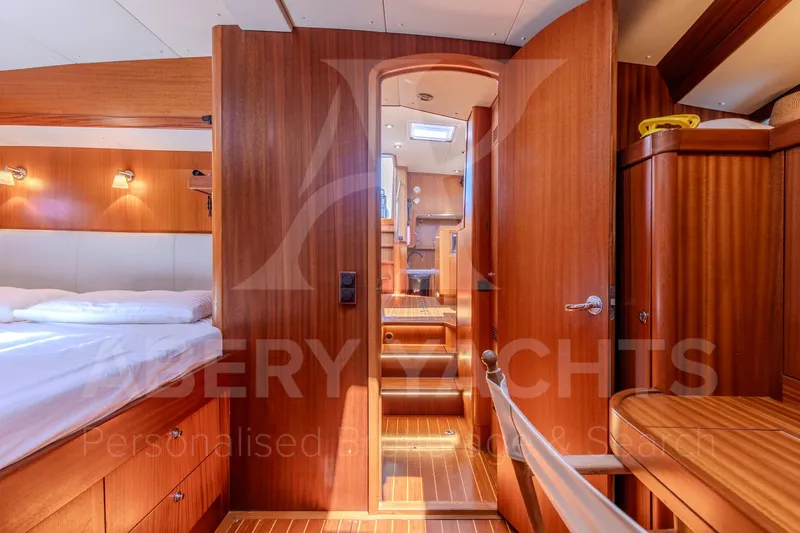 Satori Yacht Photos Pics Luxurious interior of a 2005 Farr 64 yacht with wooden finishes and cozy lighting.