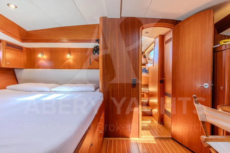 Satori Yacht Photos Pics Luxurious Farr 64 yacht interior, 2005 model, featuring a cozy bedroom with wooden finishes.