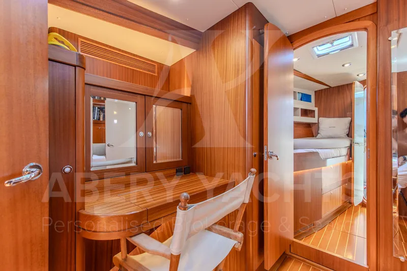 Satori Yacht Photos Pics Luxurious wooden interior of a 2005 Farr 64 yacht cabin with seating and bed.