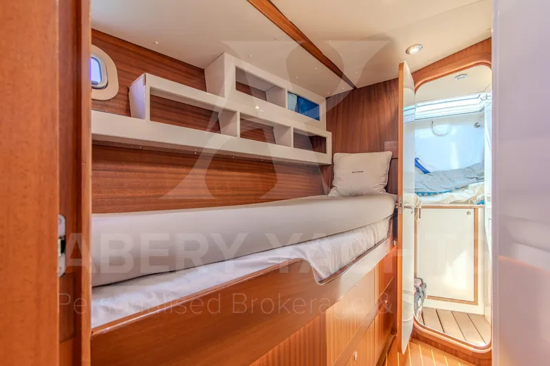 Satori Yacht Photos Pics Luxurious cabin interior of 2005 Farr 64 yacht with wooden finish and cozy bedding.