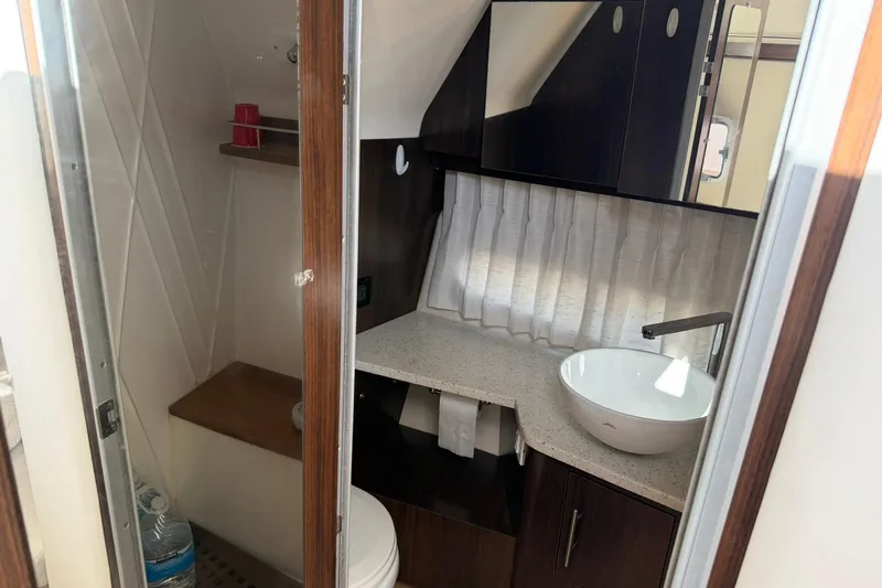  Yacht Photos Pics 2019 Regal 33 SAV boat bathroom with modern sink and wooden cabinetry.