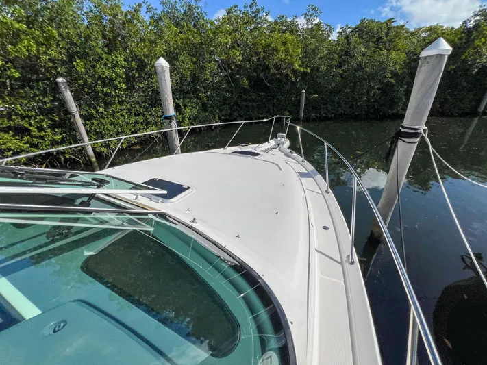  Yacht Photos Pics 2008 Tiara Yachts 3900 Sovran docked near lush greenery.