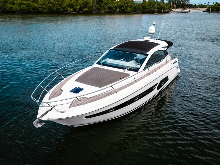 Amici Yacht Photos Pics 2019 Azimut Atlantis 43 yacht on calm water, surrounded by lush greenery.