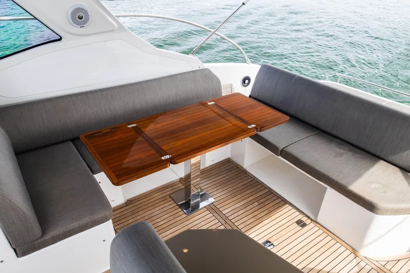Amici Yacht Photos Pics Luxurious seating area on 2019 Azimut Atlantis 43 yacht with wooden table and ocean view.