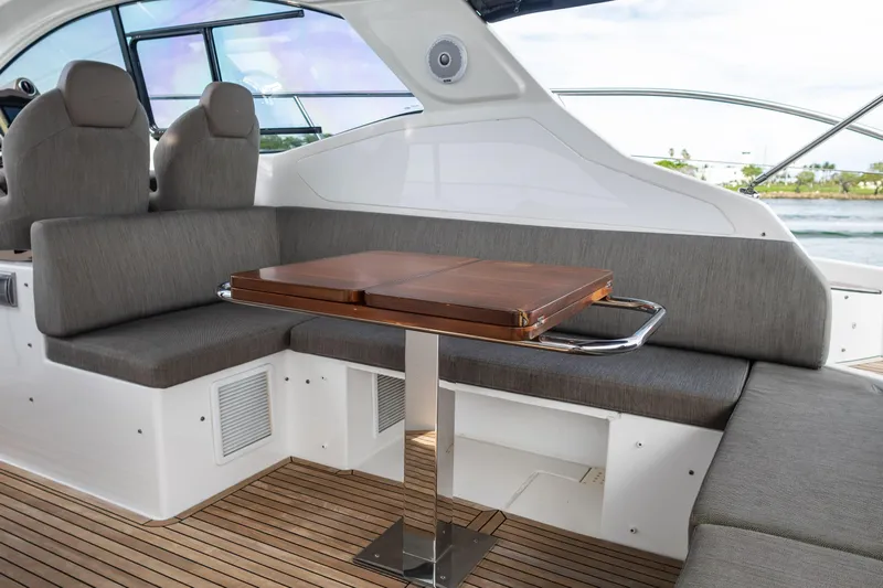 Amici Yacht Photos Pics Luxurious seating area on 2019 Azimut Atlantis 43 yacht with wooden table and gray cushions.