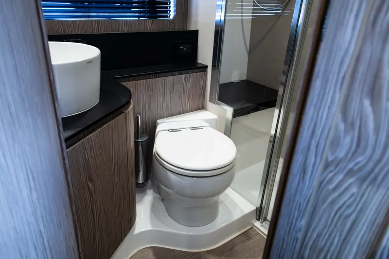 Amici Yacht Photos Pics Luxurious bathroom in 2019 Azimut Atlantis 43 yacht with modern fixtures and wood accents.