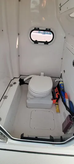  Yacht Photos Pics 2023 Blue Wave 2800 Makaira boat interior with compact marine toilet and storage.