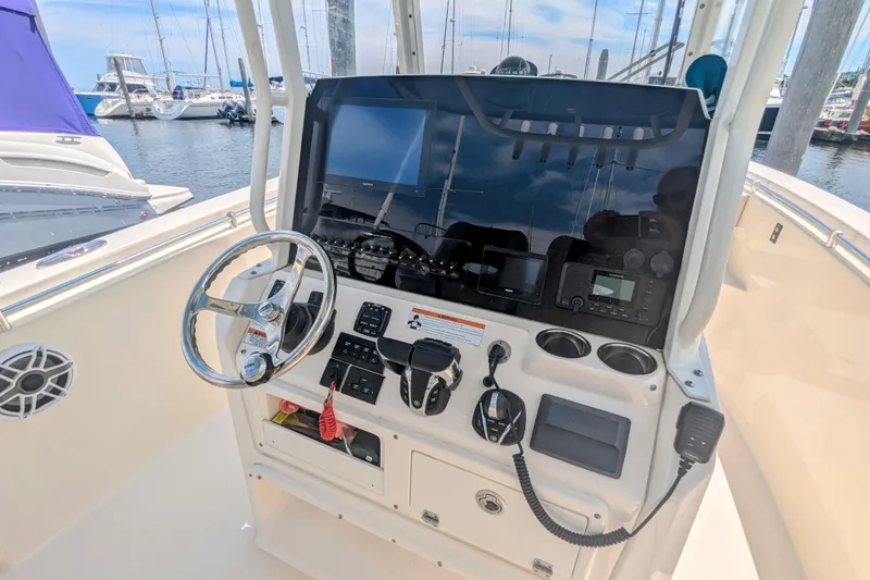  Yacht Photos Pics 2023 Cobia 280 Center Console helm with steering wheel and navigation equipment.
