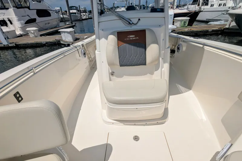  Yacht Photos Pics 2023 Cobia 280 Center Console boat interior at marina, featuring seating and clean design.