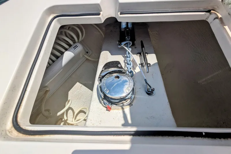  Yacht Photos Pics Anchor storage compartment on 2023 Cobia 280 Center Console boat, featuring coiled rope and metal fittings.