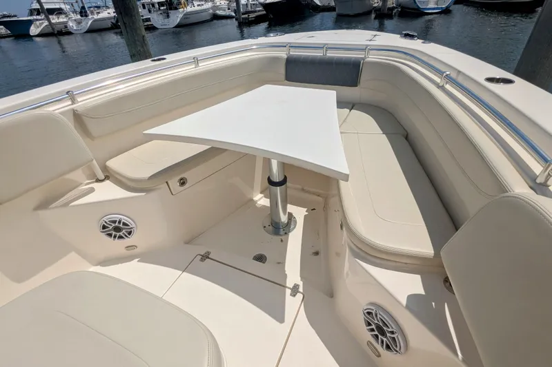  Yacht Photos Pics 2023 Cobia 280 Center Console boat interior with seating and table, docked at marina.