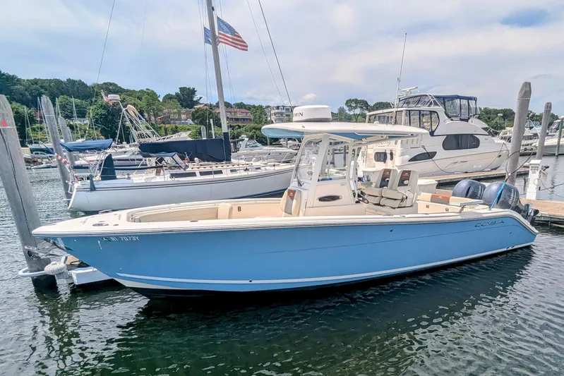  Yacht Photos Pics 2023 Cobia 280 Center Console boat docked in a marina, surrounded by other vessels.