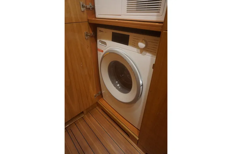  Yacht Photos Pics Built-in washing machine on Elling E6 yacht, 2026 model, with wooden cabinetry.