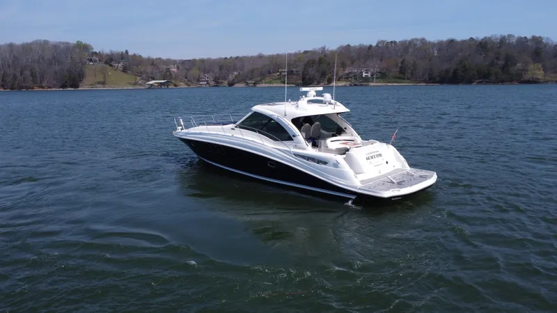  Yacht Photos Pics 2006 Sea Ray 48 Sundancer yacht on a serene lake with wooded shoreline.