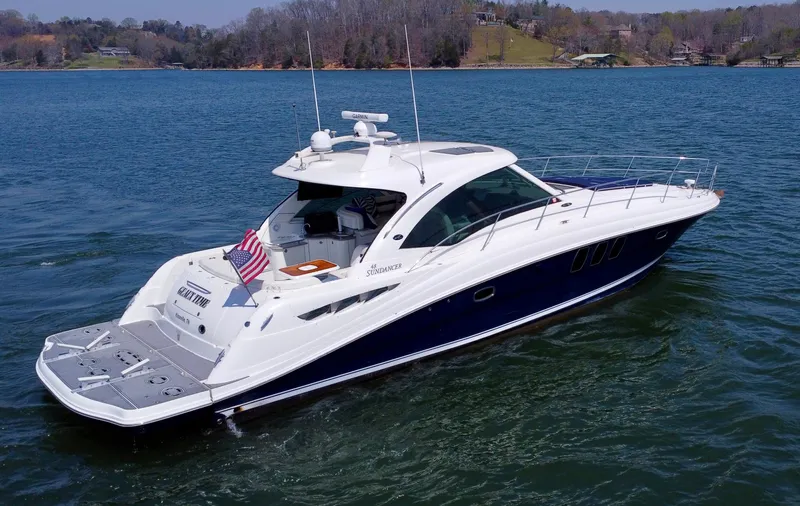  Yacht Photos Pics 2006 Sea Ray 48 Sundancer yacht cruising on a serene lake with scenic background.