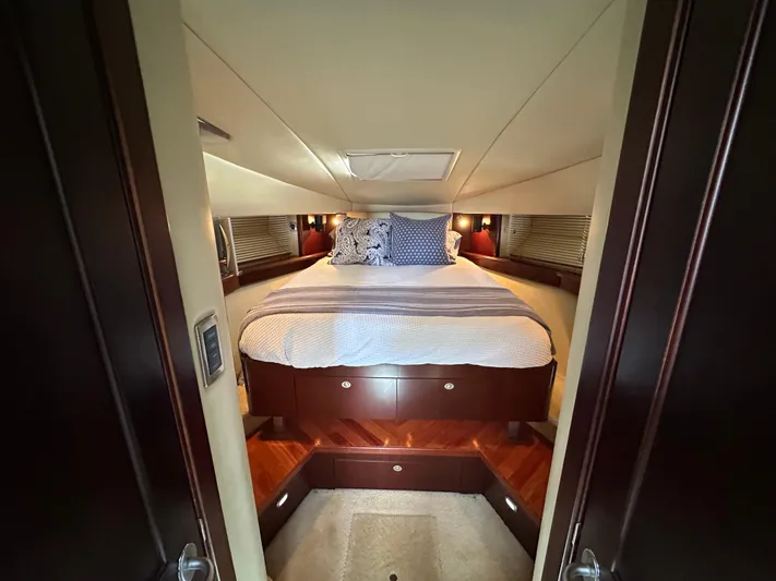  Yacht Photos Pics Luxurious cabin interior of 2006 Sea Ray 48 Sundancer yacht with cozy bed and elegant wood finish.