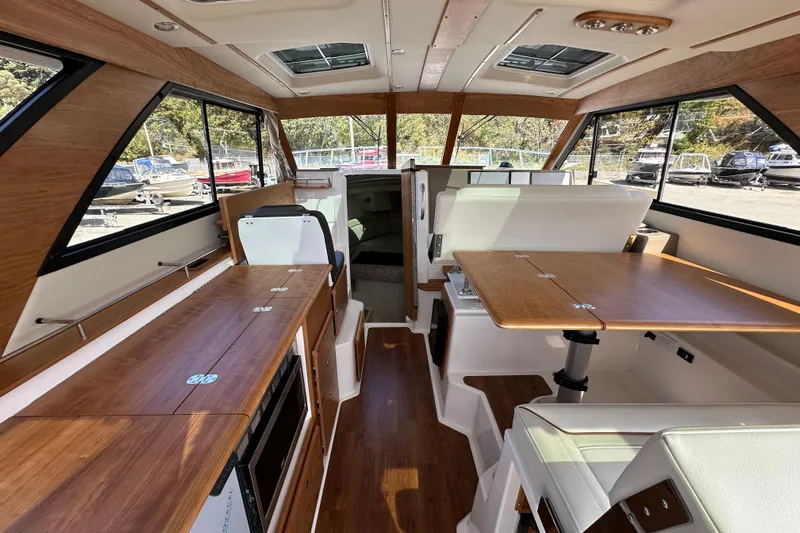  Yacht Photos Pics Interior of 2026 Cutwater C-32 C boat with wood accents and seating area.