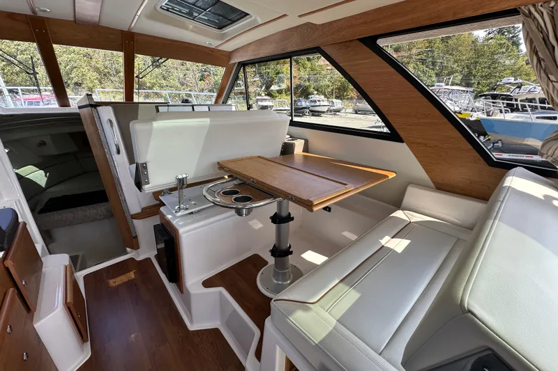  Yacht Photos Pics Interior of 2026 Cutwater C-32 C boat with seating and wooden table.