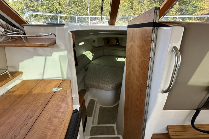  Yacht Photos Pics 2026 Cutwater C-32 C cabin interior with wood accents and cozy sleeping area.