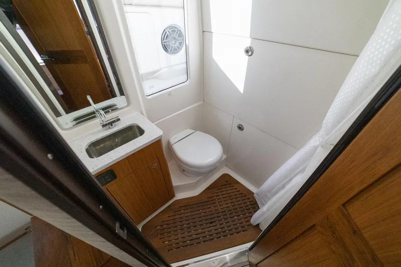  Yacht Photos Pics Manufacturer Provided Image: 2022 Solace 41 CS boat bathroom with sink, toilet, and wooden flooring.