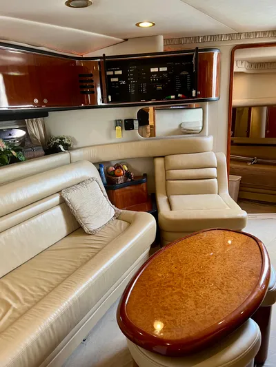 Party Of 9 Yacht Photos Pics Luxurious interior of 2004 Sea Ray 46 Sundancer yacht with leather seating and wooden table.