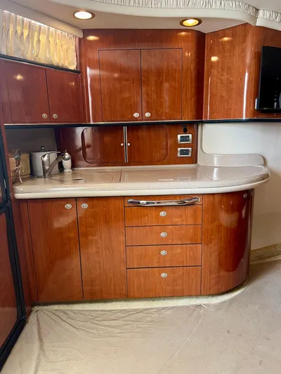 Party Of 9 Yacht Photos Pics Luxurious kitchen area in a 2004 Sea Ray 46 Sundancer yacht with wooden cabinetry.