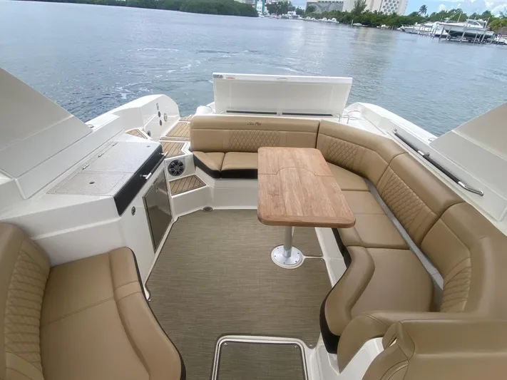 Casa - 2021 Sr 350 Slx @ Cancun (imp. Definitiva) Yacht Photos Pics 2021 Sea Ray SLX 350 boat interior with tan seating and wooden table.