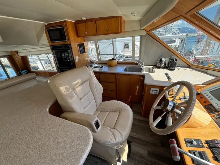 "spirit Island" Yacht Photos Pics Luxurious 2004 Navigator 4400 pilot house interior with steering wheel and kitchen area.