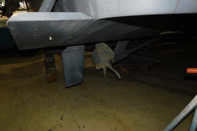  Yacht Photos Pics 1999 Sea Ray 500 Sundancer propeller and rudder detail in a workshop setting.