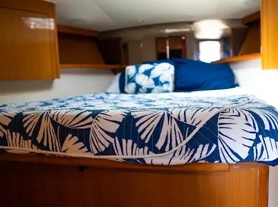 My Way Yacht Photos Pics 1999 Viking Express cabin with a cozy bed, featuring blue and white leaf-patterned bedding.