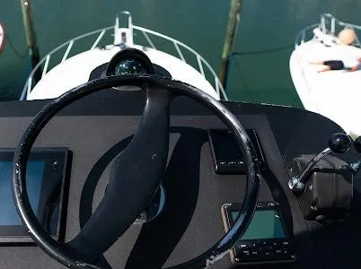 My Way Yacht Photos Pics Steering wheel of a 1999 Viking Express boat with control panel, docked at marina.