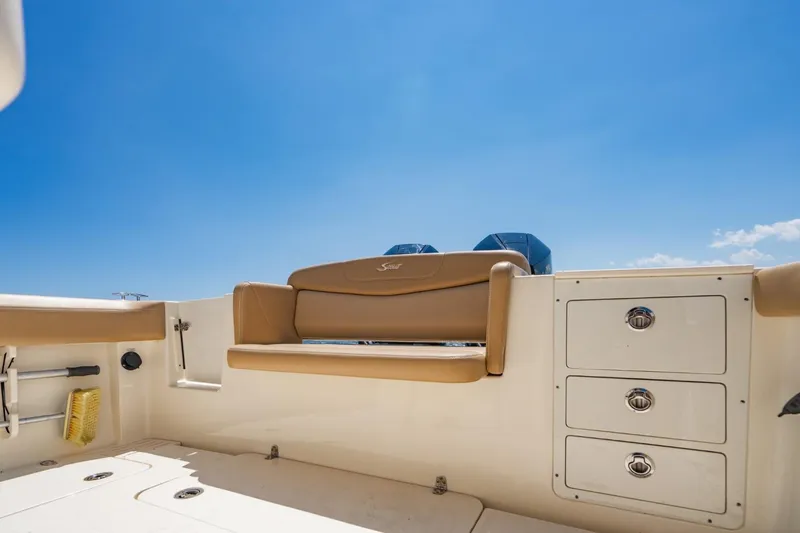  Yacht Photos Pics 2022 Scout 305 LXF boat interior with seating and storage under clear blue sky.