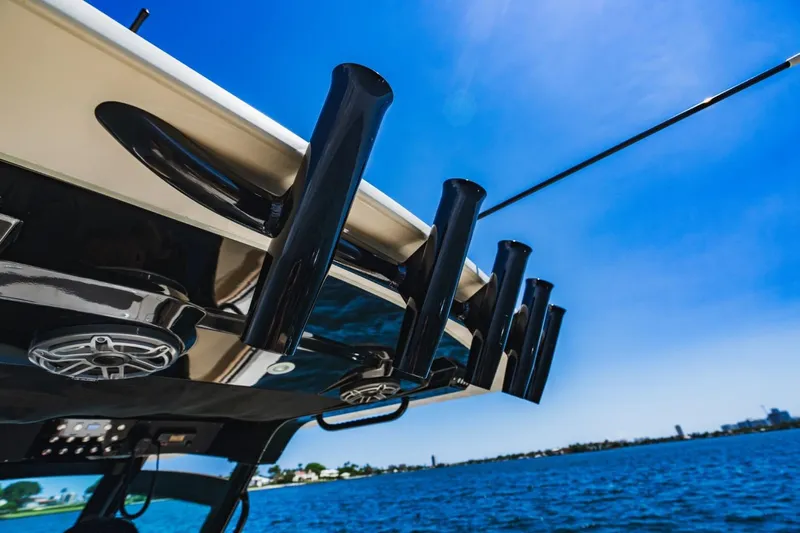  Yacht Photos Pics 2022 Scout 305 LXF boat with rod holders against a clear blue sky.