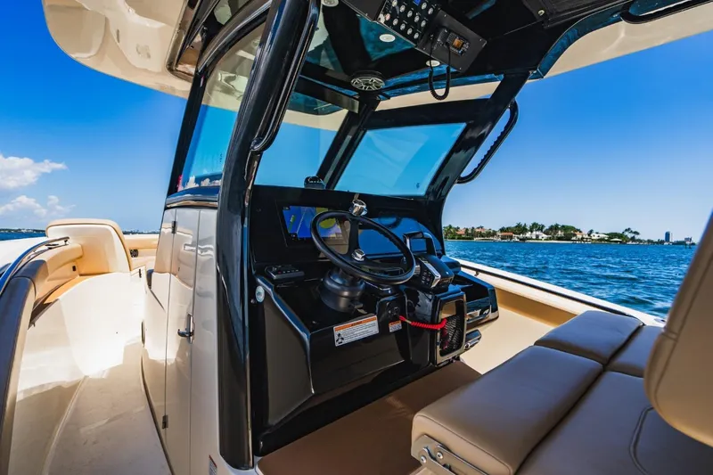  Yacht Photos Pics 2022 Scout 305 LXF boat interior with steering console, on a sunny day at sea.