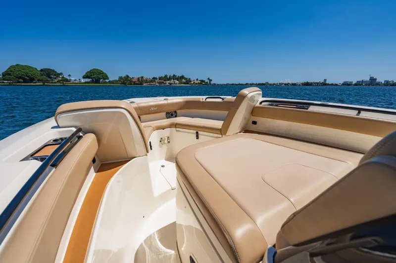  Yacht Photos Pics 2022 Scout 305 LXF boat interior with tan seating, on a sunny day by the water.