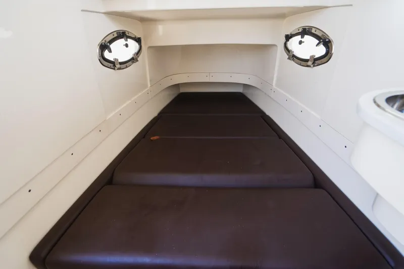  Yacht Photos Pics 2022 Scout 305 LXF cabin interior with cushioned seating and portholes.